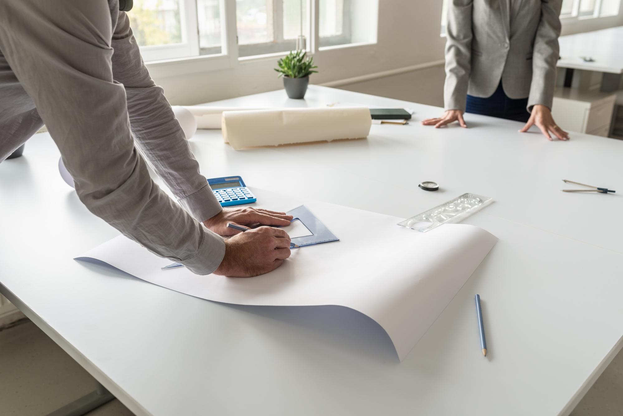 Birou de consultanță imobiliară cu planuri pe masă